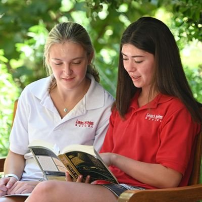 upper school students reading a book