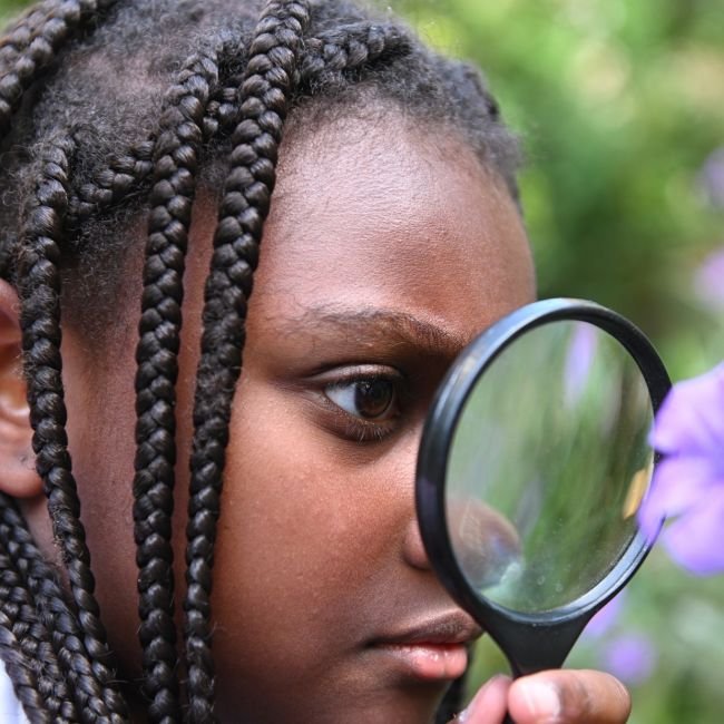 lower school student with magnifying glass